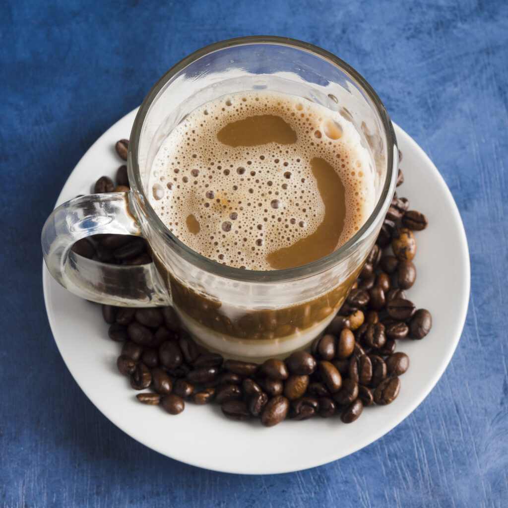 Top view of a cup filled with black coffee on a saucer.